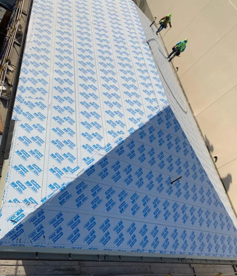 Professional roofers installing underlayment on a metal roof in Bountiful